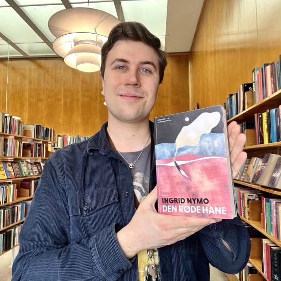 Mathias holder et eksemplar af bogen "Den røde hane".