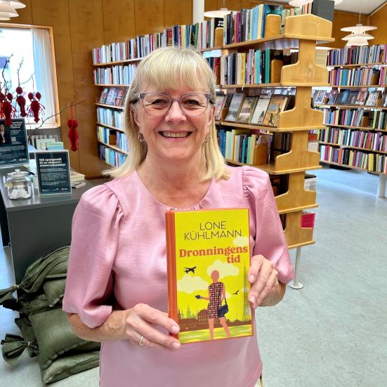 Bibliotekar Anni Bagge Jensen med bogforsiden til "Dronningens tid"