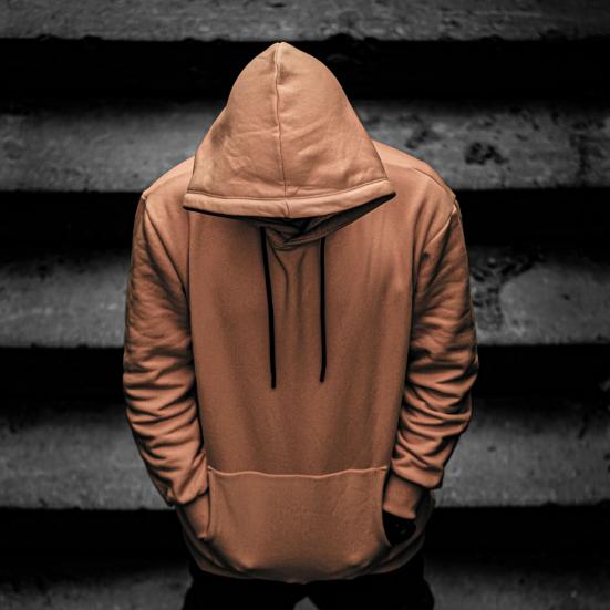 Ung person i gul hoodie går ned ad trappe med bøjet hoved.