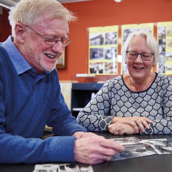 Frivillige smiler mens de ser på gamle billeder.