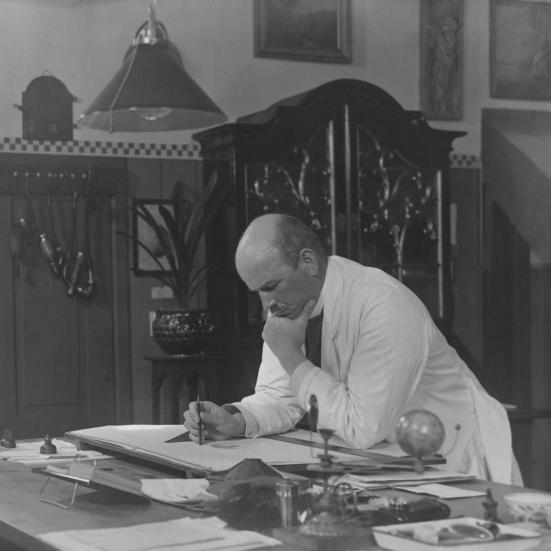 Billede fra Nyborg Lokalhistoriske Arkiv. August Colding står og arbejder ved sit tegnebord. Ukendt fotograf.