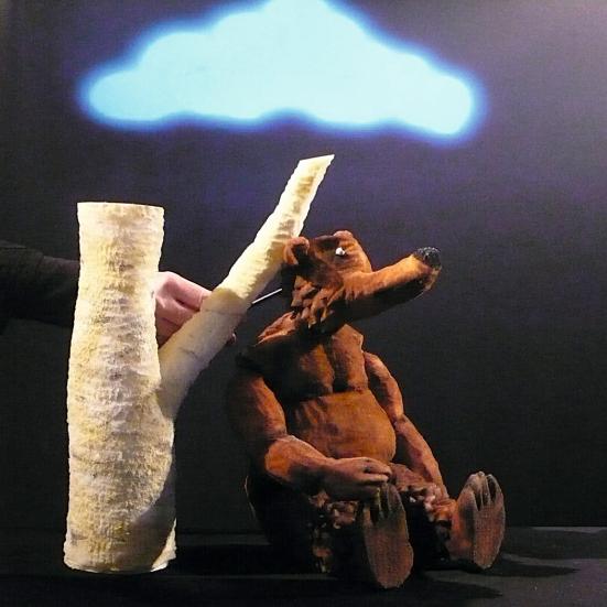 En bjørnedukke læner sig op ad et træ.