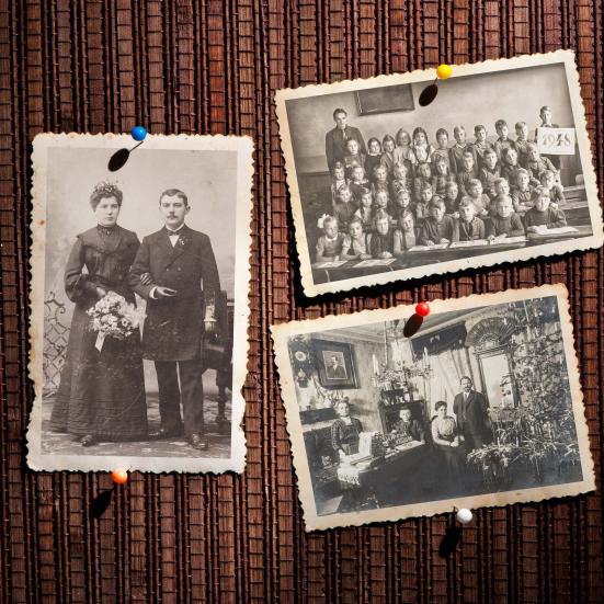 Gamle sort/hvid-fotografier på en opslagstavle.