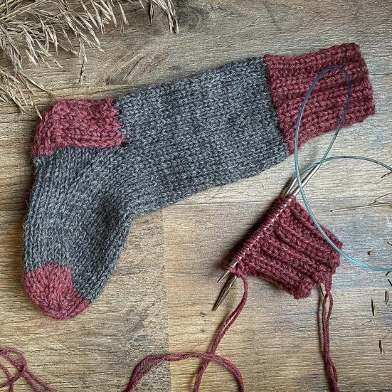 En strikket strømpe og noget garn.