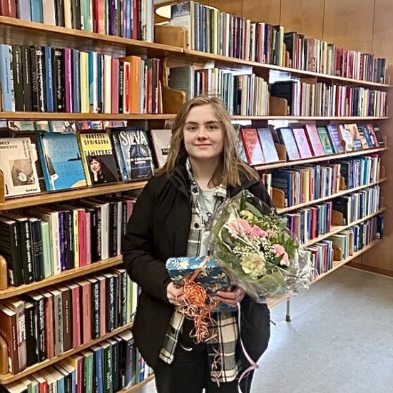 Vinder Elinor Maaløe med boggave og blomsterbukket.