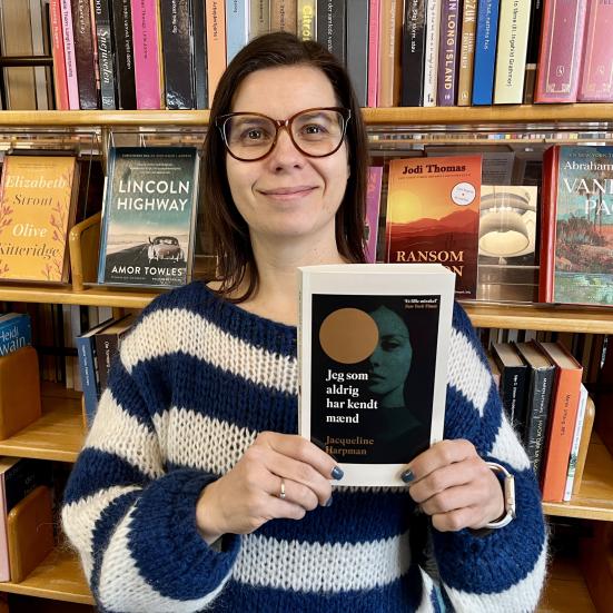 Bibliotekar Marianne Wismar Mühring står med bogen "Jeg som aldrig har kendt mænd".