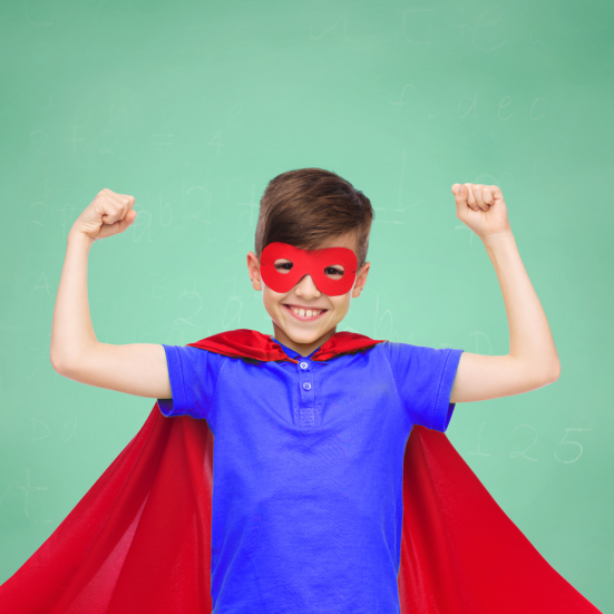Dreng i superheltekostume mod grøn baggrund.