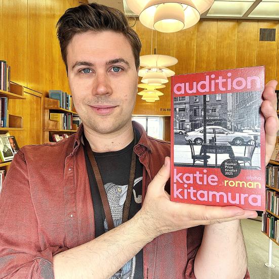 Bibliotekar Mathias Lyngs står med bogen "Audition"