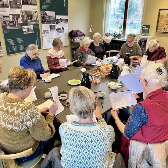 Billede af deltagerne ved en tidligere Fælleslæsning samlet omkring et bord.