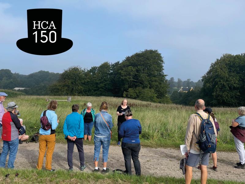 Billede fra tidligere Litteragåtur i Ørbæk samt et logo af en sort højhat med teksten HCA 150.