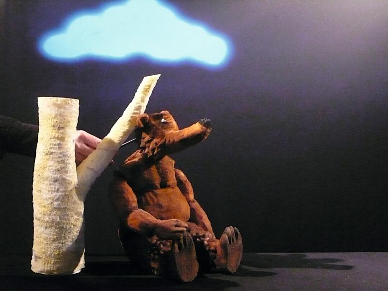 En bjørnedukke læner sig op ad et træ.