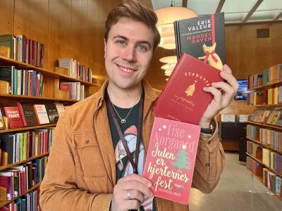 Bibliotekar Mathias Lyngs holder de tre julebøger, der omtales i artiklen.