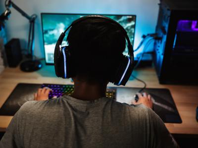 Dreng sidder foran computerskærm og gamer.