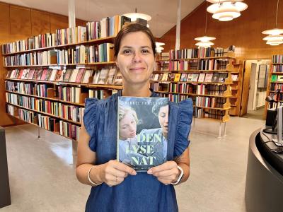 Bibliotekar Marianne Wismar Mühring med bogen "Den lyse nat".