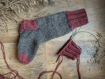 En strikket strømpe og noget garn.