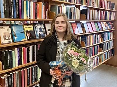 Vinder Elinor Maaløe med boggave og blomsterbukket.