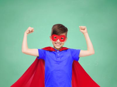 Dreng i superheltekostume mod grøn baggrund.