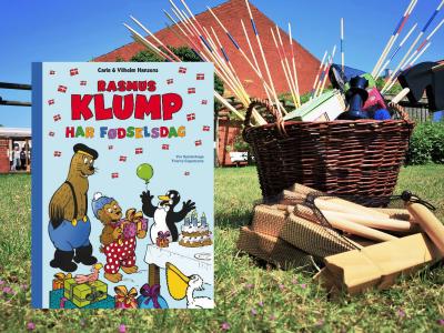 Sommerbillede fra Bibliotekshaven og bogforsiden til "Rasmus Klump har fødselsdag"