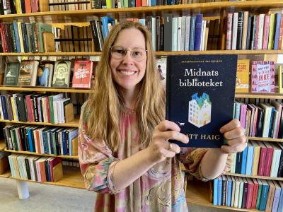 Bibliotekar Johanne Søndergaard Louv med romanen Midnatsbiblioteket.
