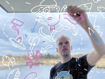 Peter Hermann står og tegner sjove illustrationer.
