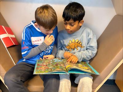 To drenge sidder og læser i bog sammen på Danehofskolens SFO-bibliotek