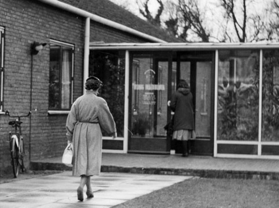 Den kvindelige låner er på vej mod bibliotekets indgangsparti …