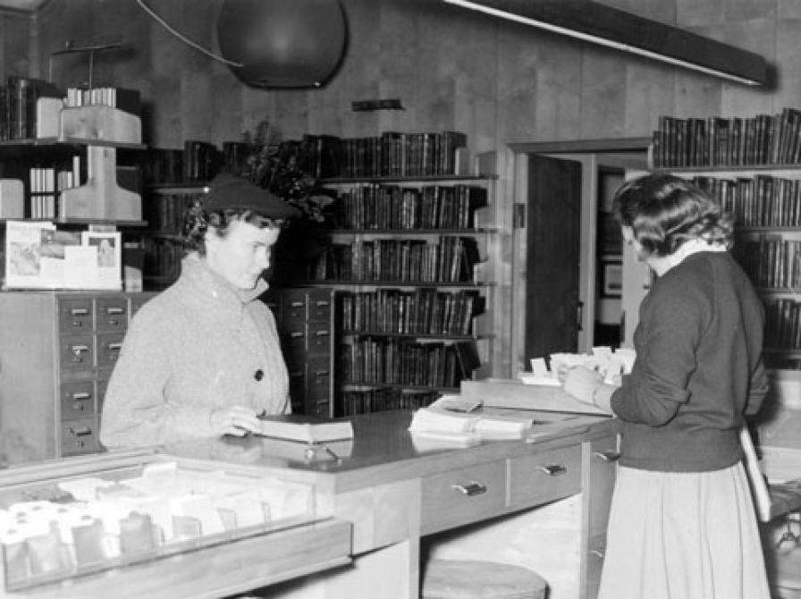 I skranken afleverer hun de medbragte bøger.