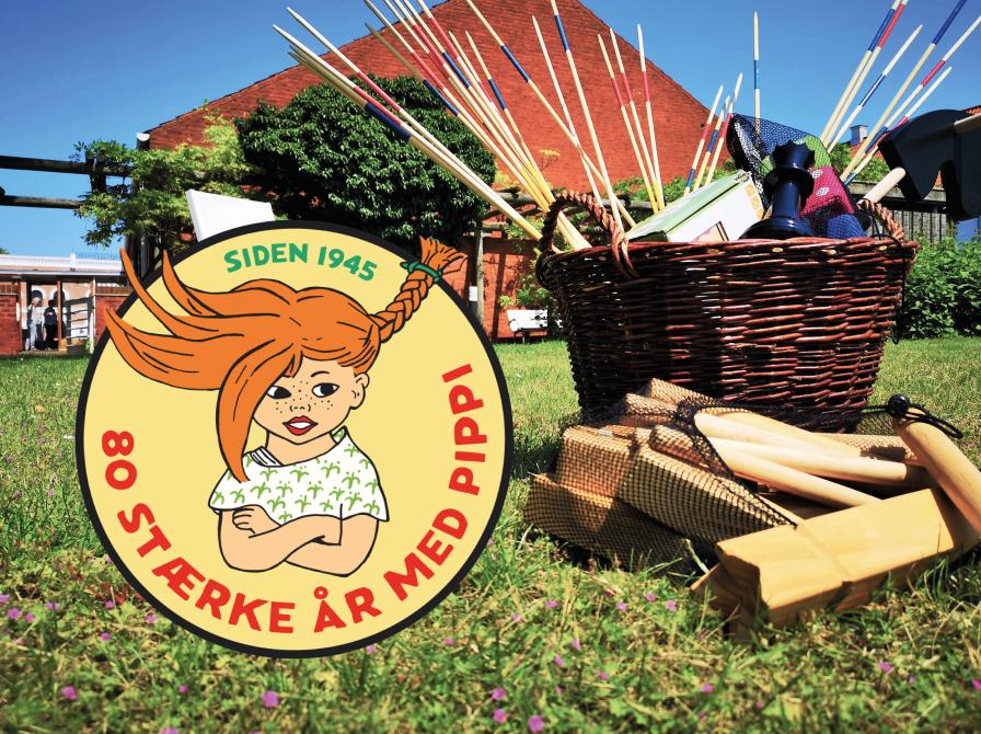 En kurv med udendørsspil i haven og et mærke med Pippe Langstrømpe og teksten: 80 stærke år med Pippi siden 1945.