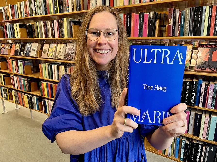 Bibliotekar Johanne Søndergaard Louv står med romanen "Ultramarin".