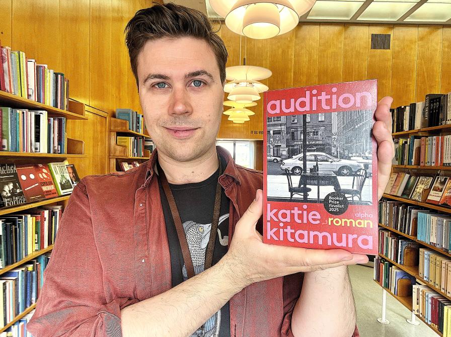 Bibliotekar Mathias Lyngs står med bogen "Audition"