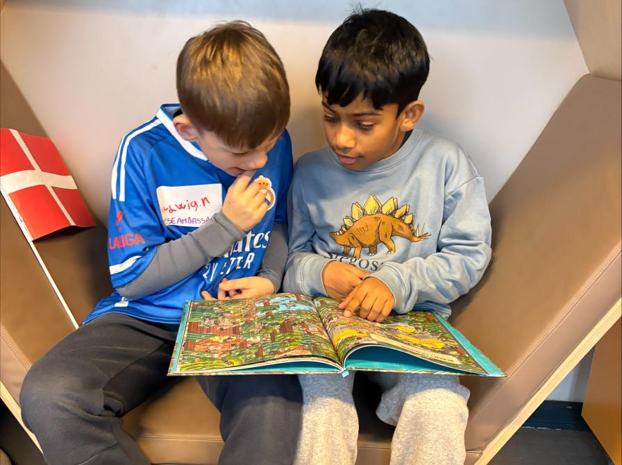 To drenge sidder og læser i bog sammen på Danehofskolens SFO-bibliotek